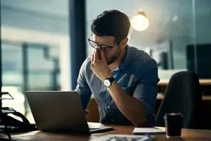 Shot of a young businessman experiencing stress during a late night at work because of connectivity issues